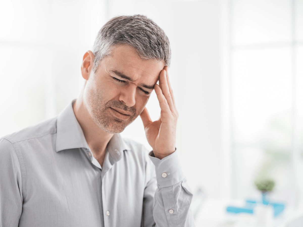 headache a man holding his head in pain with a headache