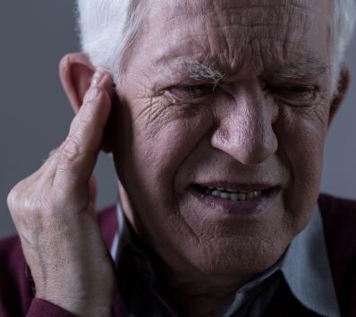 Tinnitus 3 Old man scrunching his face with ear pain