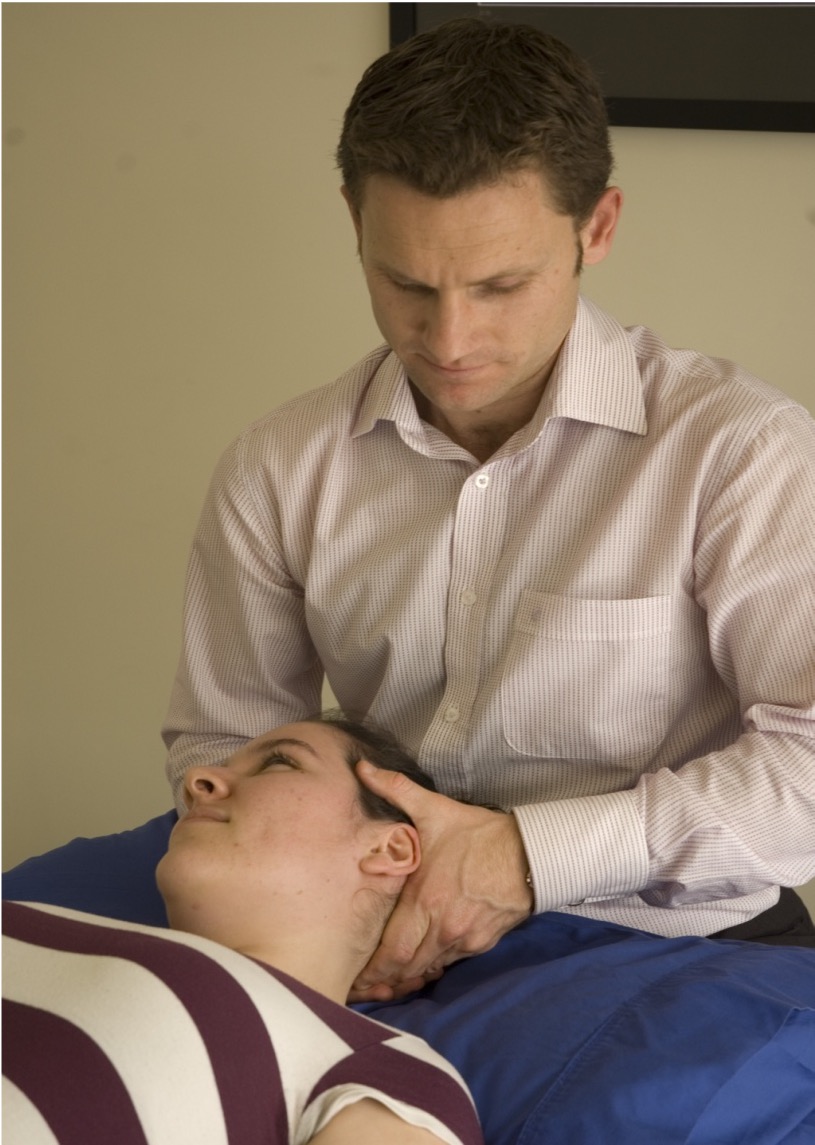 Scott holding a ladies head, performing a treatment