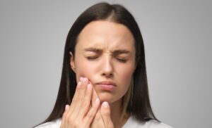 Lady holding the side of her mouth in pain