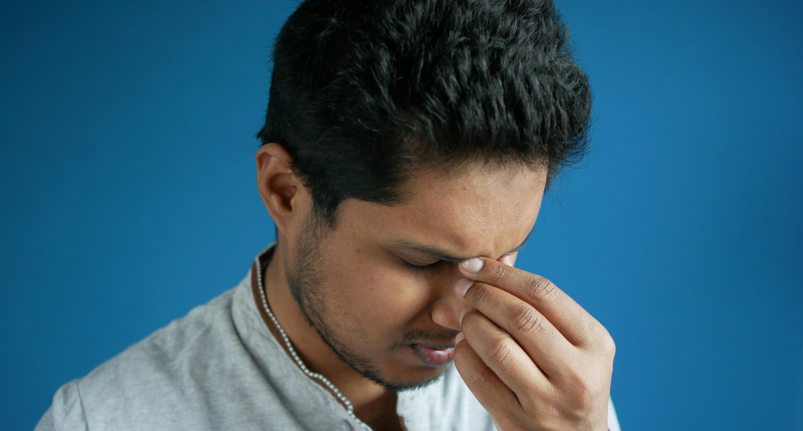 Man suffering from headache holding head