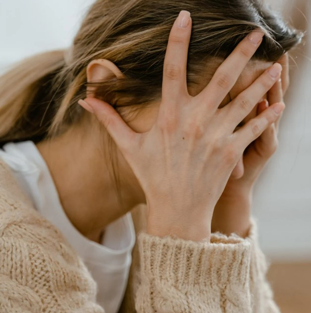 Stressed woman with head in her hands