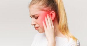 Lady holding aching ear