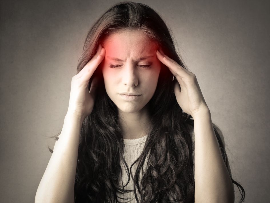 Lady suffering from headache holding her head