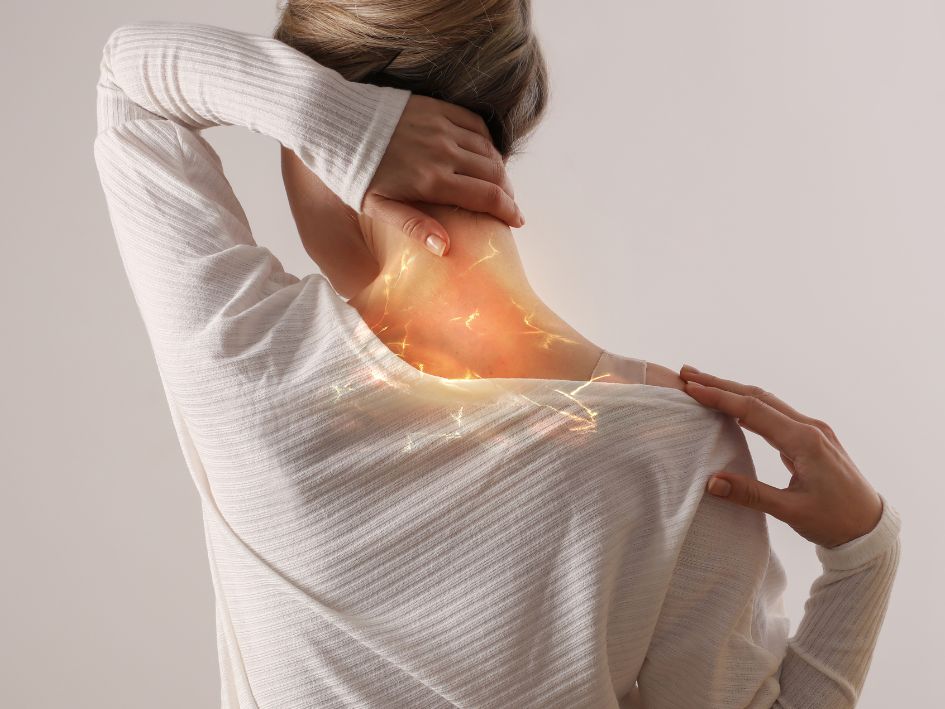 Lady with neck pain holding her neck and shoulder. 