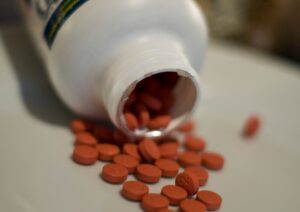 Painkillers spilling out of bottle onto bench