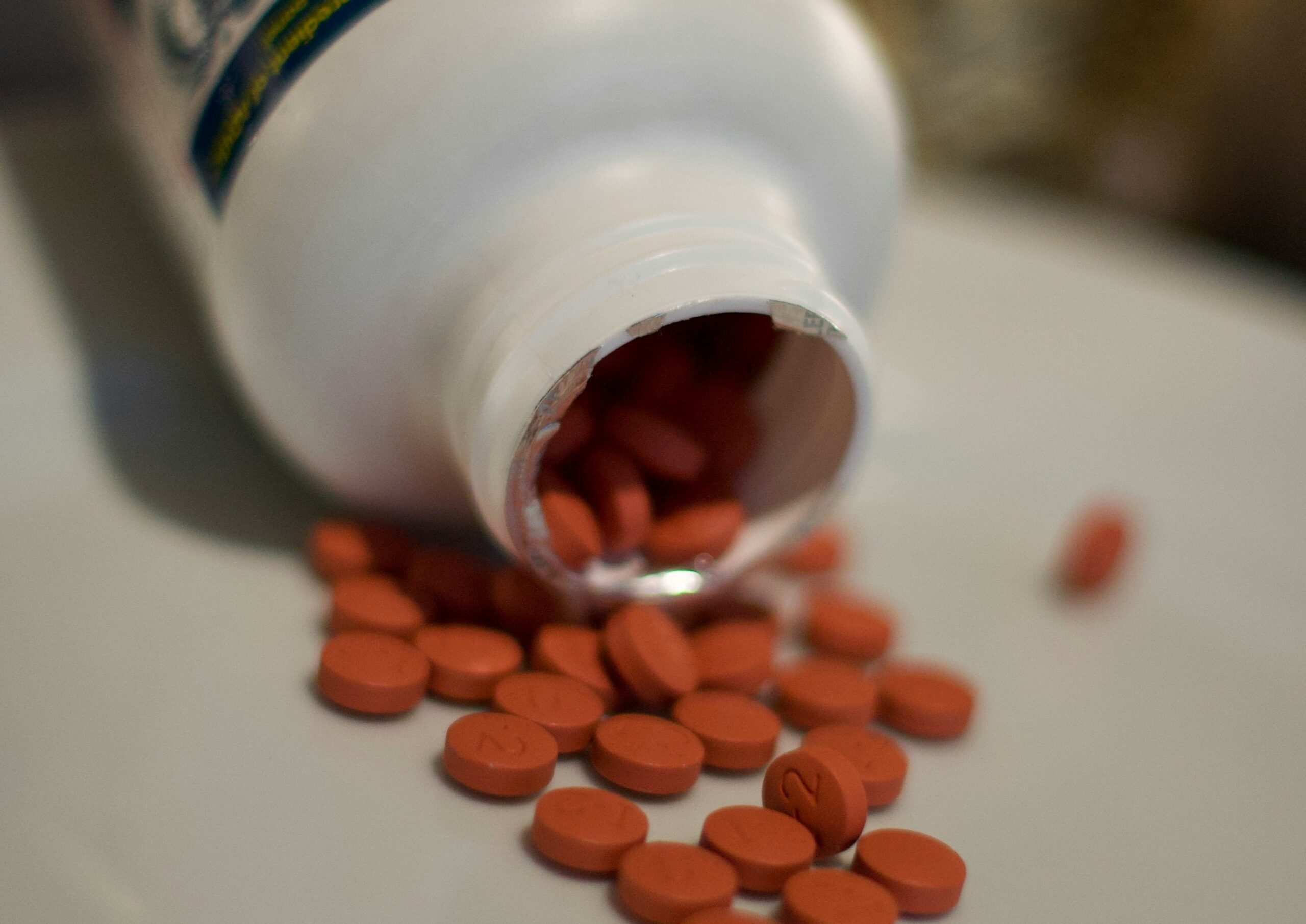 Painkillers spilling out of bottle onto bench