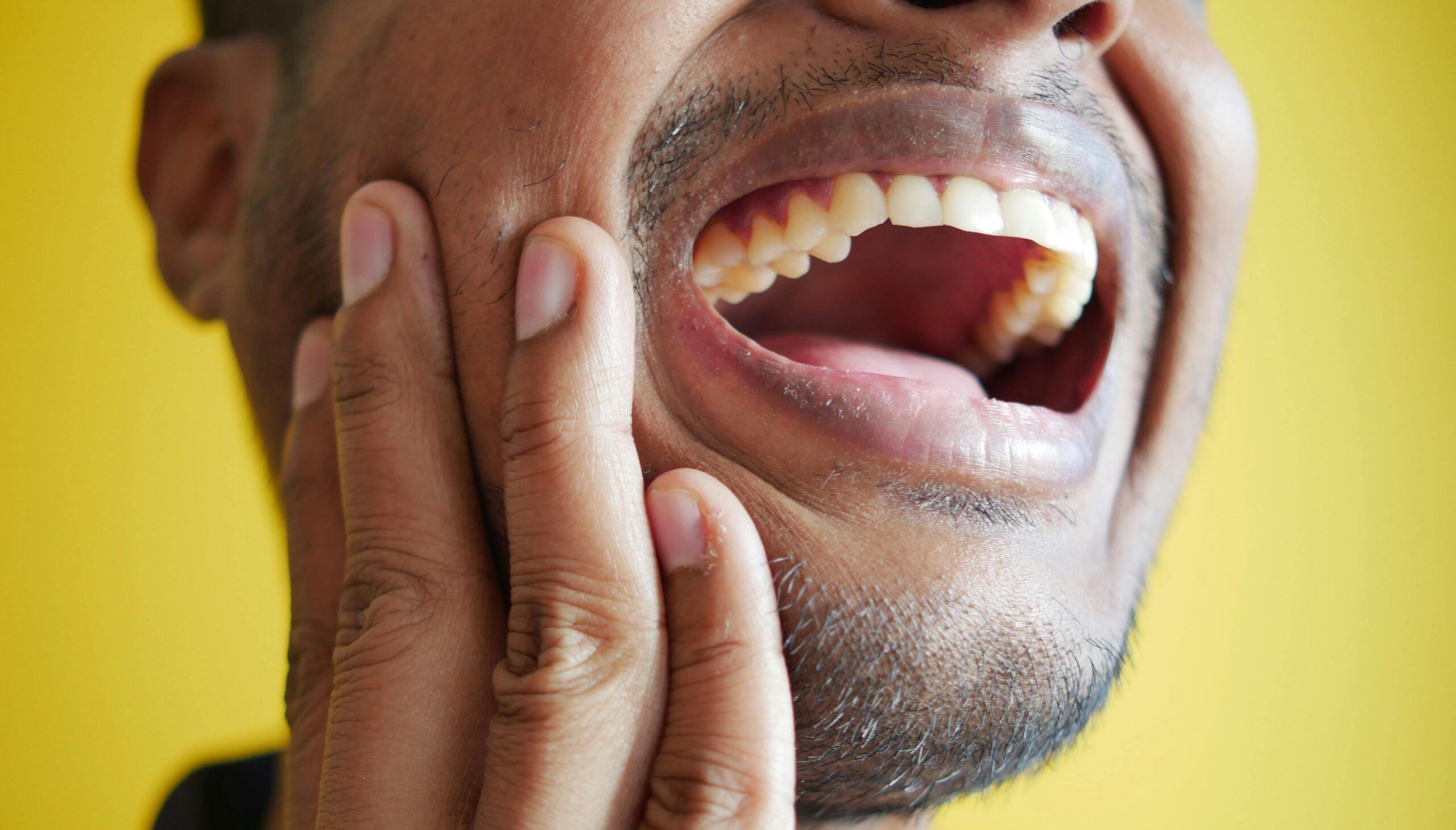 Close up of man holding painful jaw